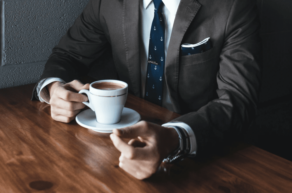 man wearing suit drinking coffee in consultation