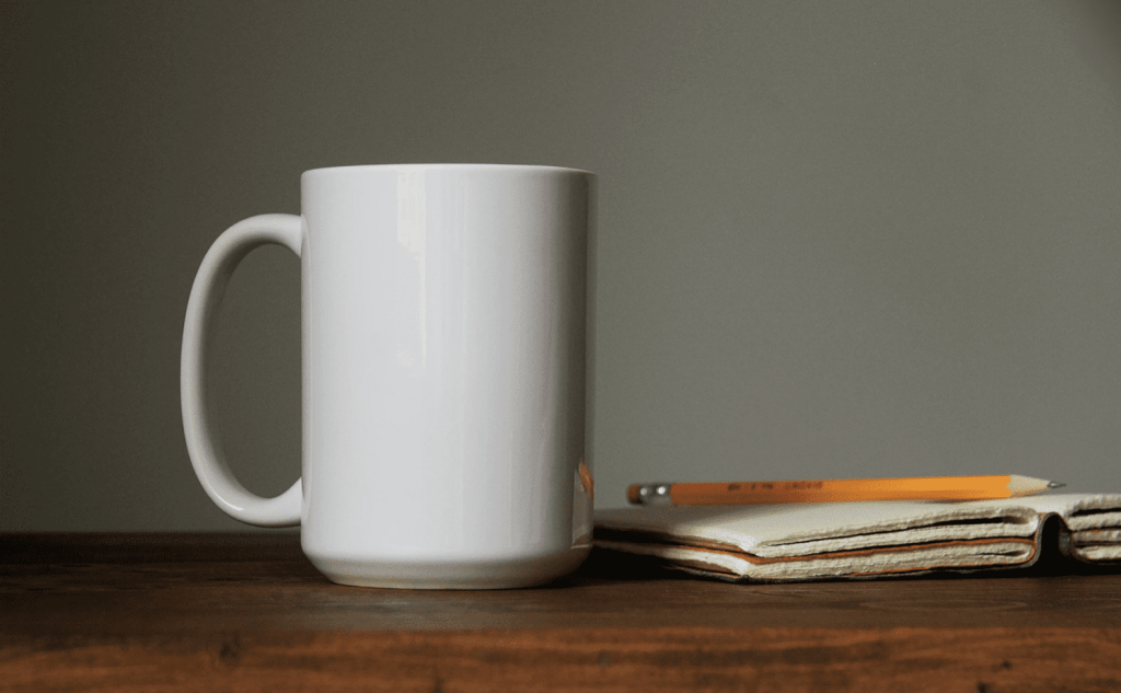 mug on desk with notebook on side