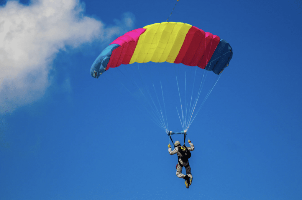 parachuting in the sky with clouds behind