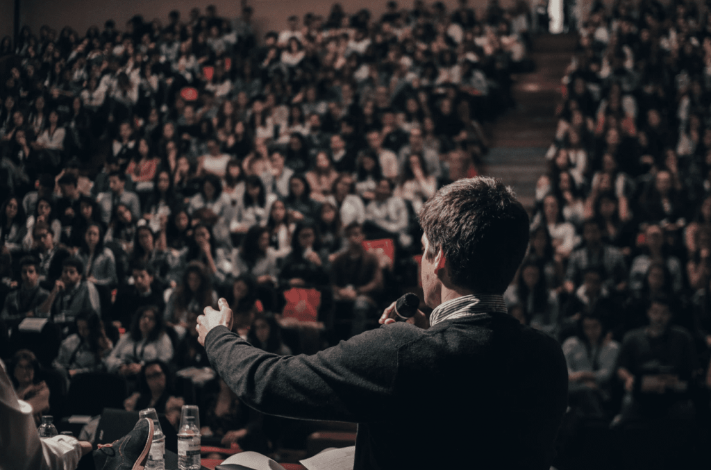 man standing infront of a crowd giving a speech campaign