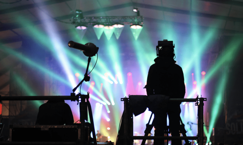 performer standing infront of main stage with lights and coloured walls