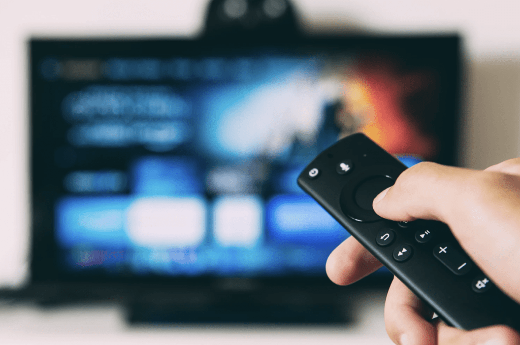 man holding smart tv remote infront of smart tv