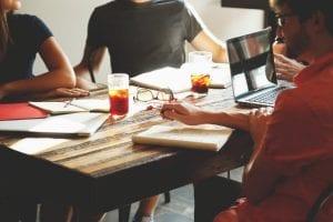 A group of people sat around having a meeting with tea and coffee. Strong teams are essential to raising VC investment.