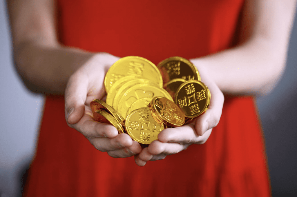 scam designer holding a pile of coins
