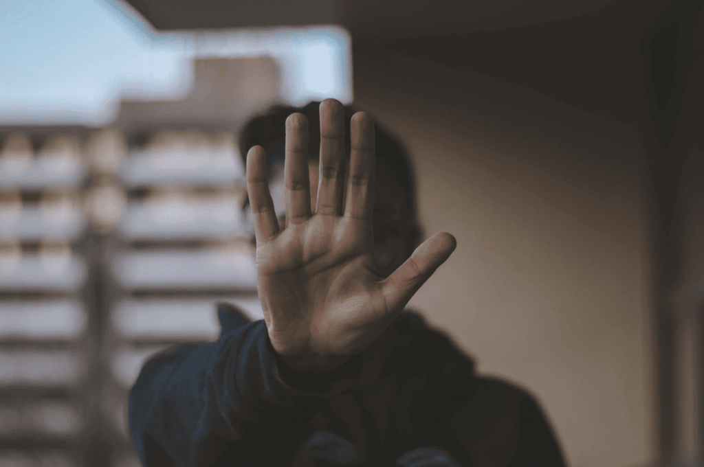 person holding their hand up to say stop to scam design on the internet