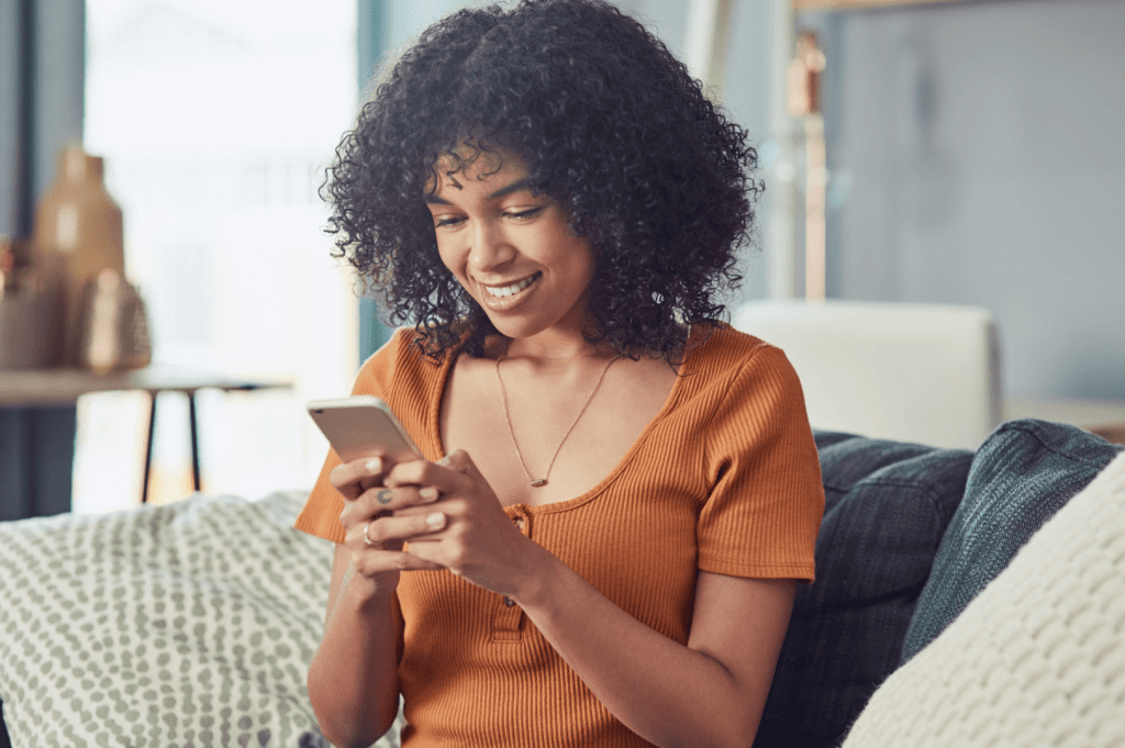 woman looking down at phone and smiling