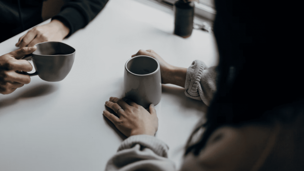 a client and freelancer talking over coffee negotiating a day rate